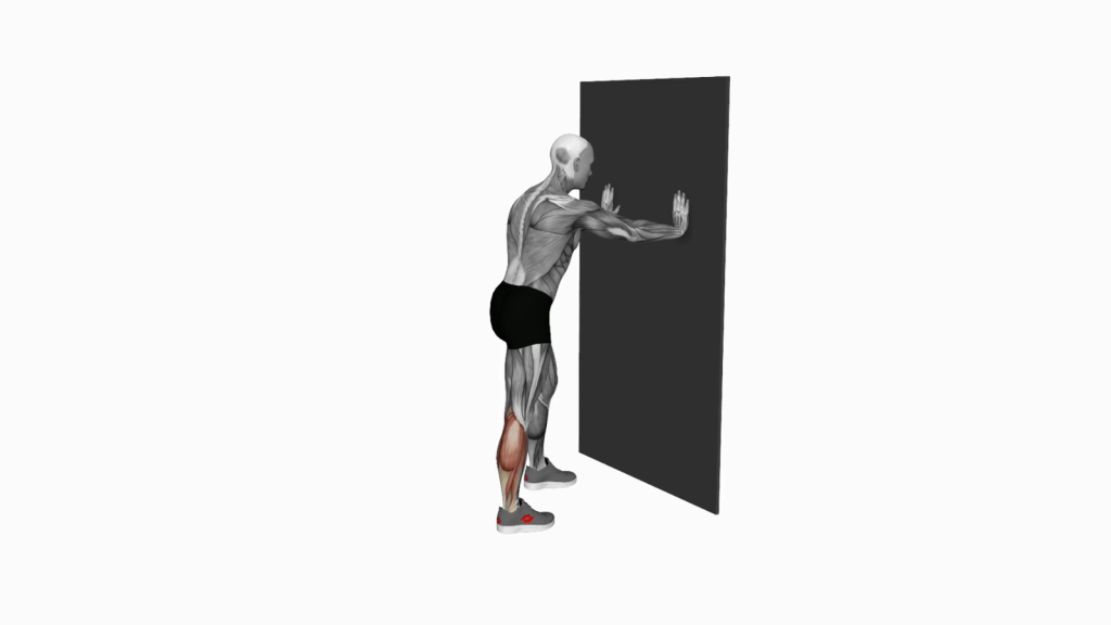 Person doing calf stretch against a wall, showcasing correct stance and alignment for effective stretching.